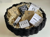 Hand woven black rope sewing hamper containing seven Merchant & Mills haberdashery items.